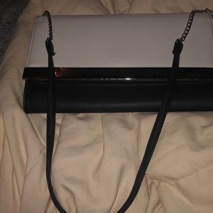 Bland and white purse with strap included has one pocket black on the inside